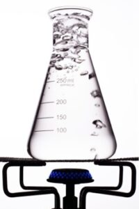 A beaker of boiling water sitting on a Bunsen burner.